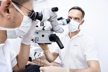 Dr. Schmid und Dr. Hofmann am OP-Mikroskop während einer Wurzelkanalbehandlung