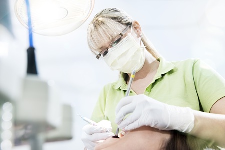 Prophylaxe-Mitarbeiterin am Patienten während einer PA-Behandlung