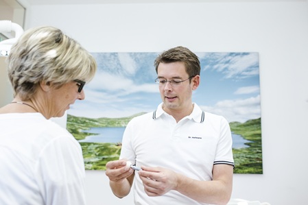Dr. Hofmann berät eine Patientin zu Implantaten